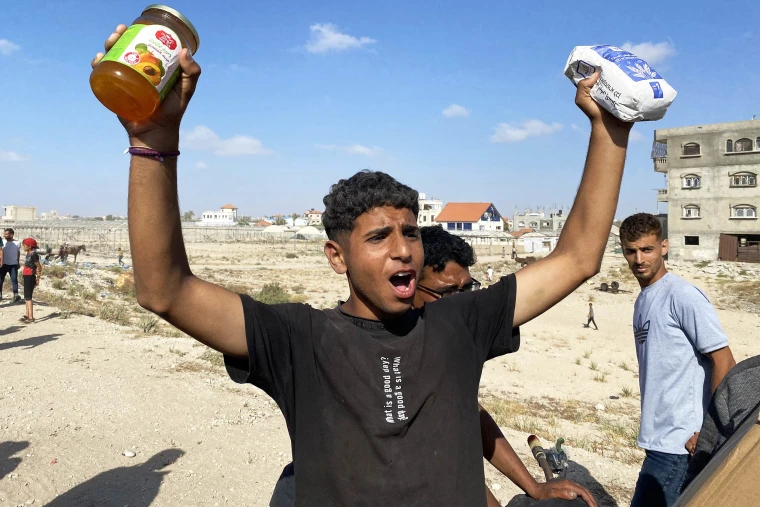 A young man holding food supplies outdoors